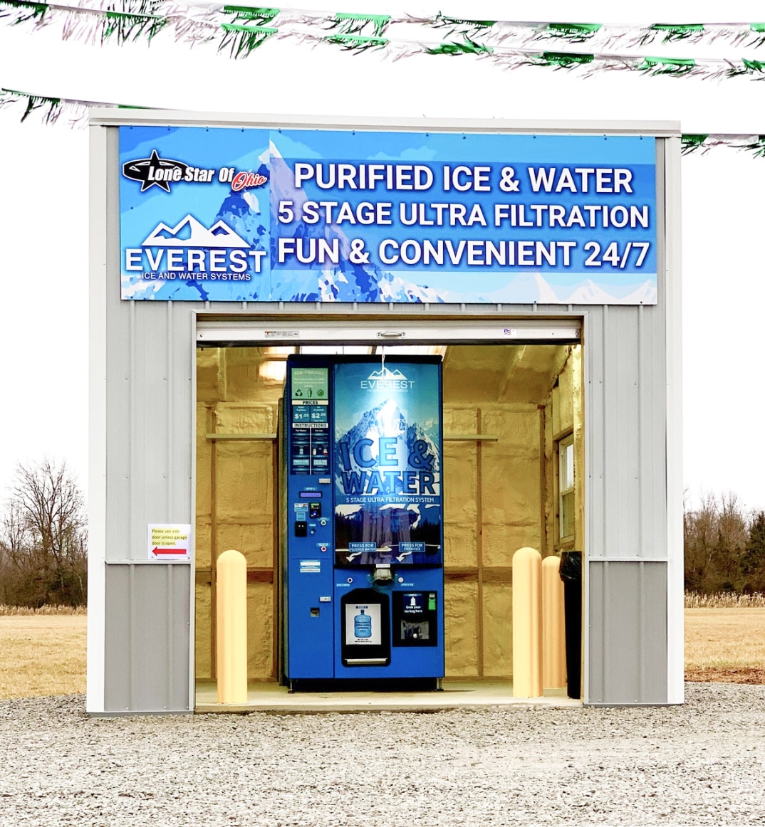 A portable storage building with Lone Star of Ohio branding on it where an Everest Ice and Water vending machine is housed